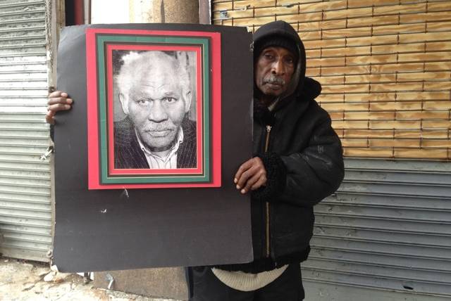 Clarence Hardy with a picture of Judge John L. Phillips Jr., who had court-order guardianship of the theater in the early 2000s